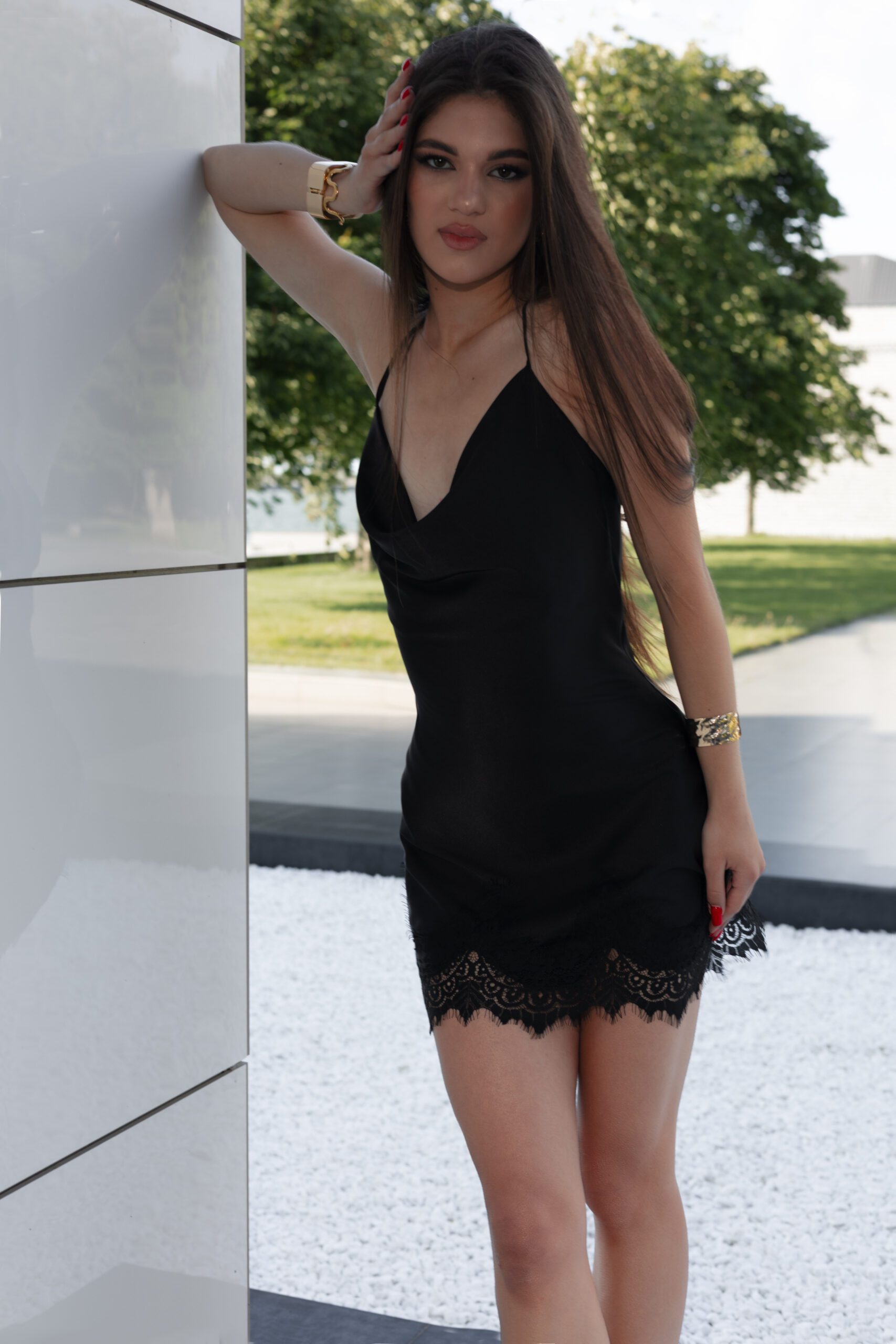 Модель у платті VALERY Black (напівпрозора) чорного кольору від бренду Her Name спирається рукою на білу плитку